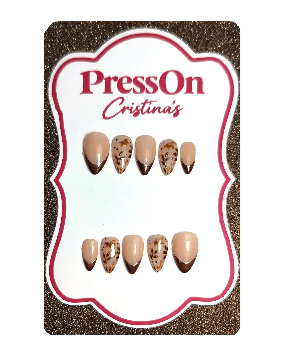 Uñas postizas almendra con francesa marrón ojo de gato y hojas otoñales pintadas a mano, sobre cartulina PressOn Cristina's, vista frontal