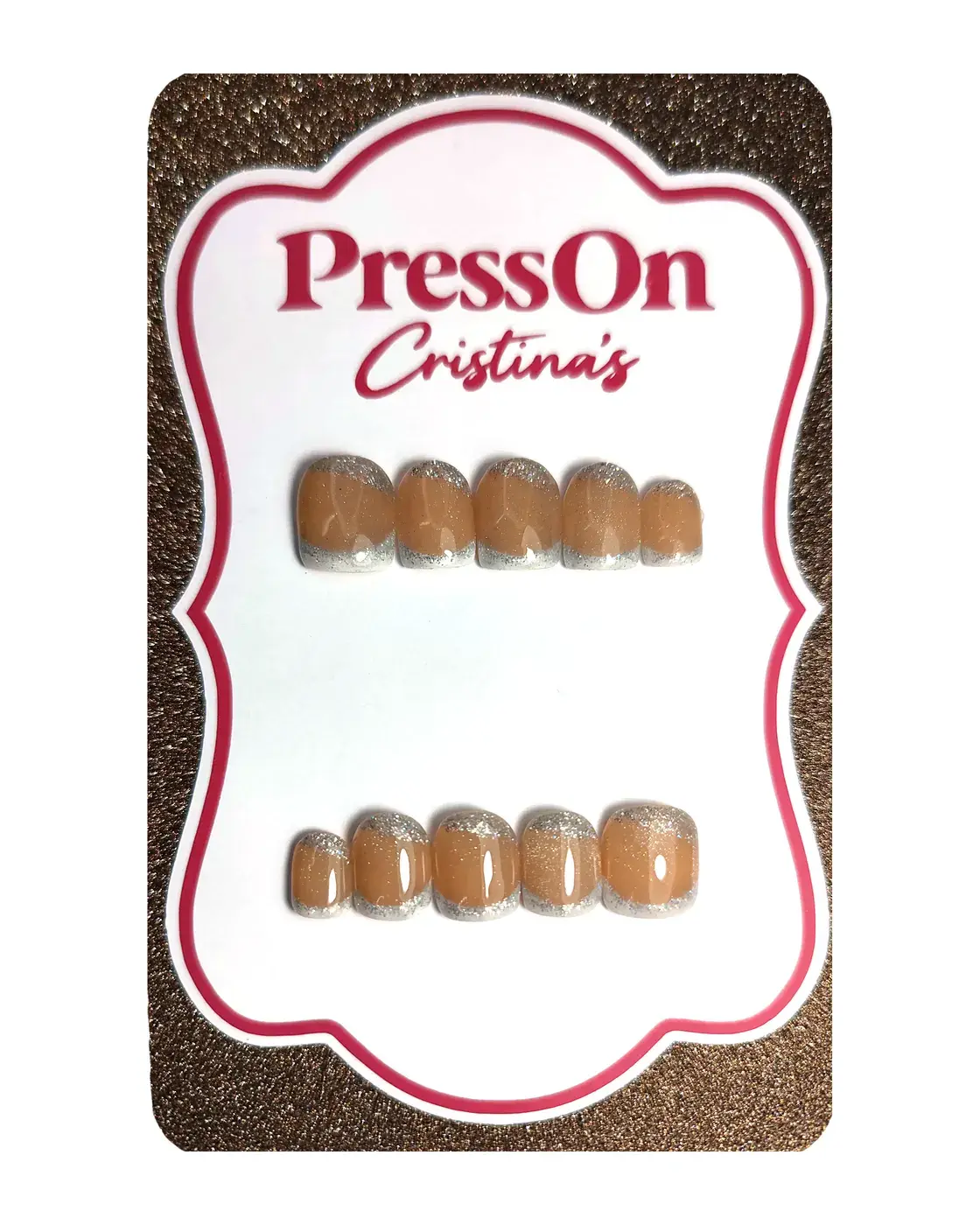 Uñas postizas squoval cortas en nude caramelo con francesa plateada con purpurina, sobre cartulina PressOn Cristina's, vista frontal
